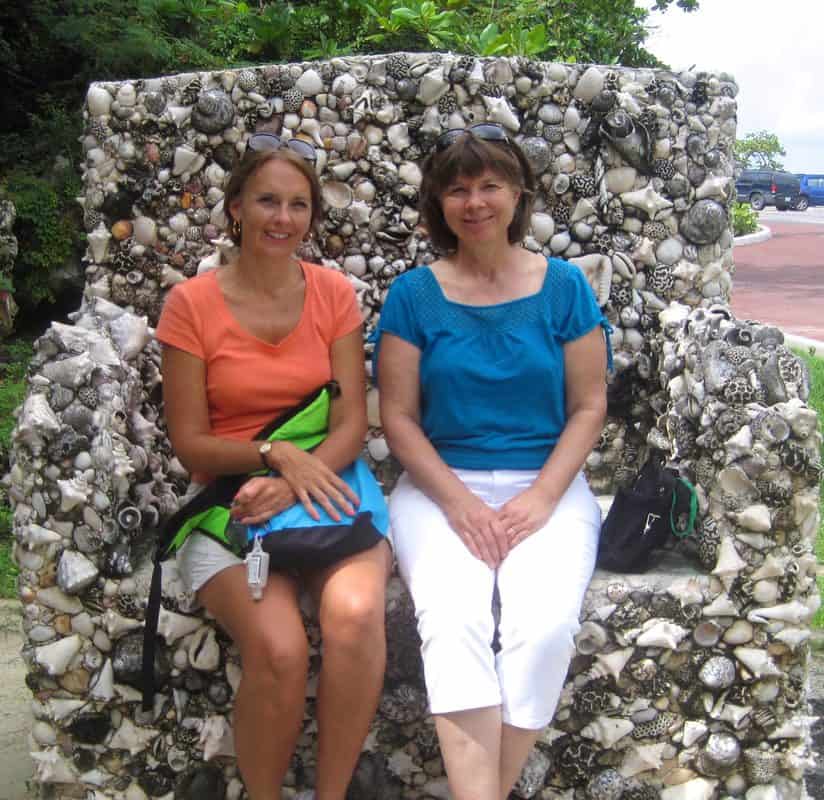 Cami and friend sitting on shell bench at The Caves in Nassau