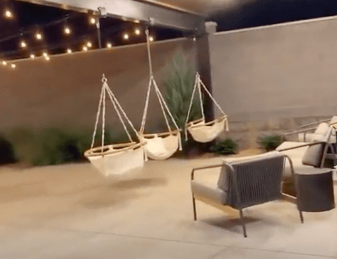 outdoor lounge space at Radcliffe Hotel with hanging chairs, outdoor seating, twinkle lights
