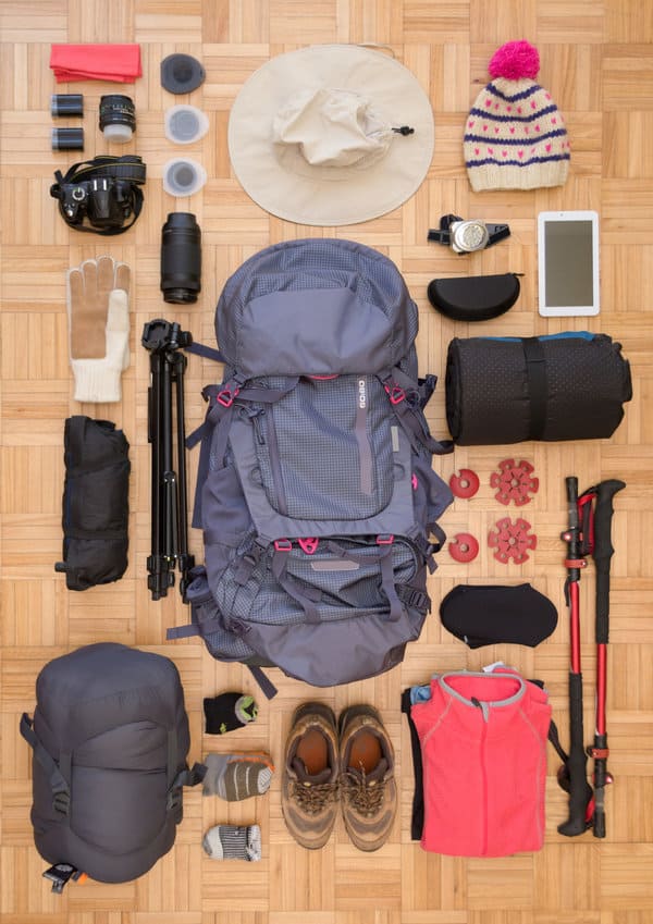 Items for hiking arranged around a gray backpack