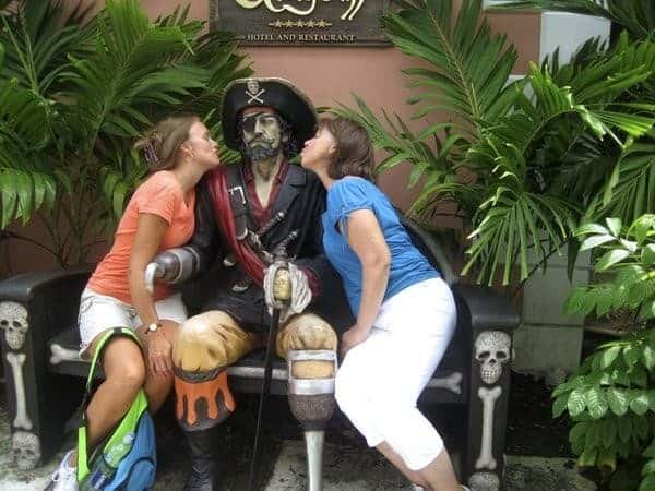 Two ladies kissing pirate statue at Graycliff Chocolatier in Nassau Bahamas.