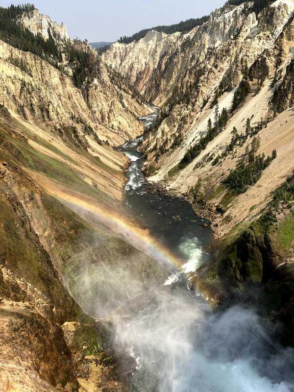View of Lower Falls surrounded by mountains with rainbow