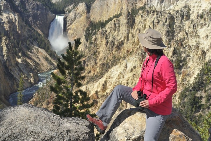 Person resting and looking at waterfall on Yellowstone National Park hikes